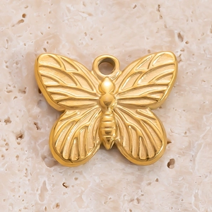 Vue macro d'un pendentif papillon doré montrant la texture des ailes et le fini métallique