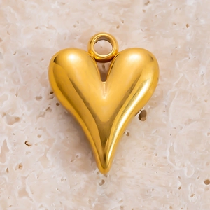 Vue macro d'un pendentif coeur doré 3D avec finition polie et anneau de suspension