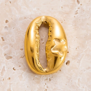 Vue macro d'un pendentif coquillage doré avec relief étoilé sur socle corail blanc