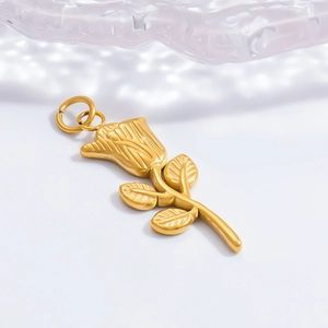 Détail d'un pendentif en forme de rose dorée avec pétales gravés et double anneau de saut