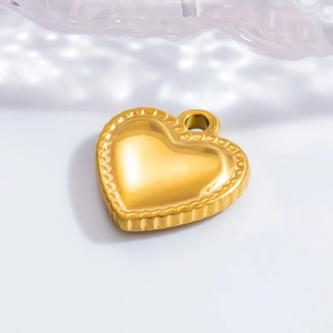 Vue macro d'un pendentif coeur 3D doré avec bords texturés sur fond blanc épuré