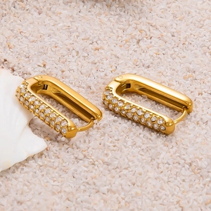 Détail de créoles rectangulaires plaquées or 18k avec double rangée de zircons sur sable