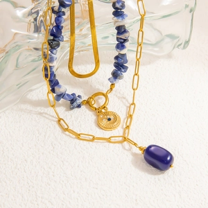 Close-up of triple layered gold necklace with blue natural stone and sun pendant