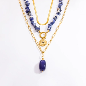 Close-up of triple layered gold necklace with flat snake chain and blue natural stones