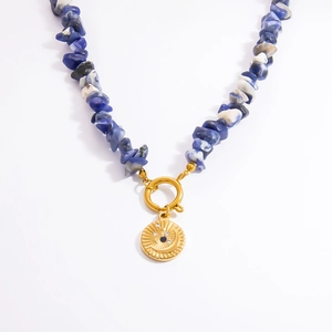 Detail of 18k gold pendant with moon star motif and blue white stone beaded necklace