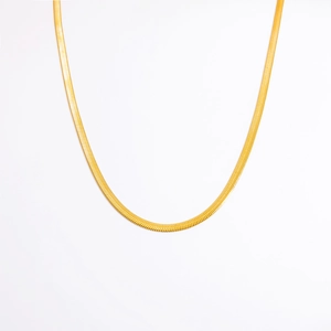 Macro shot of gold herringbone chain with a dense woven texture on a white background