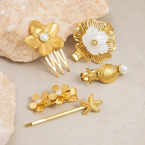Detailed close-up of gold stainless steel pearl hair clips with starfish and floral designs