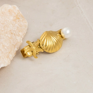 Detailed close-up of golden alloy seashell, starfish and pearl hair clip set
