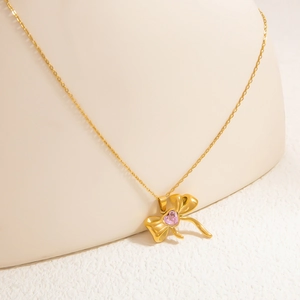 Detailaufnahme des 18K Gold Schmetterlings-Anhängers mit funkelndem rosa Herz-Kristall