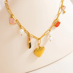 Collier chaîne trombone doré avec charms botte rose et émail présenté sur un buste blanc