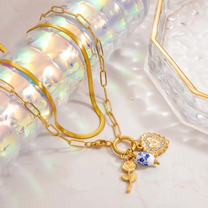 Détail du collier à couches en or 18k avec pendentif rose et breloque œil de cœur