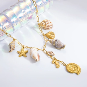 Detailed close-up of 18k gold plated shell starfish and seahorse ocean charms necklace