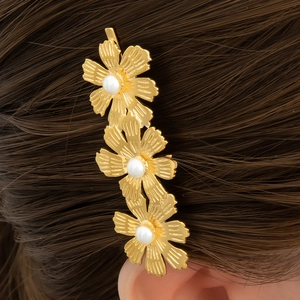 Eleganter goldener Blumen-Haarclip mit weißen Perlen auf braunem Haar für Damen