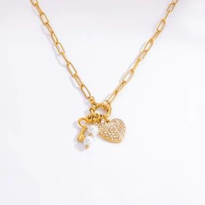 Vista detallada del collar de eslabones con colgante de corazón brillante, llave y perlas