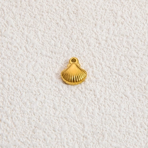 Vista macro di un ciondolo a forma di conchiglia in acciaio inossidabile placcato oro 18k