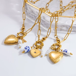 Detail of gold locket necklace with heart pendant, pearls, and blue ceramic beads