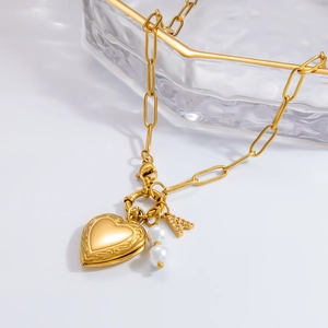 Close-up of gold paperclip chain necklace with heart pendant, pearls, and letter A charm