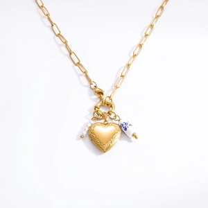 Detailed macro view of heart locket pendant with paperclip chain and floral ceramic bead