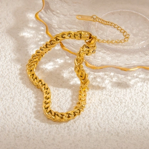 Detailed close-up of chunky gold-plated Cuban chain bracelet with lobster clasp