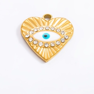 Macro detail of 18k gold heart-shaped evil eye pendant with radiant texture and crystals