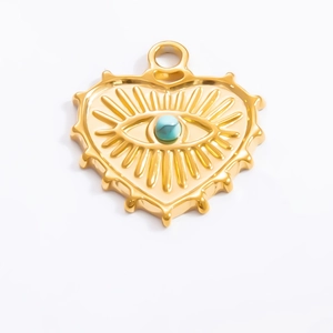 Detailed view of an 18k gold heart pendant with evil eye turquoise bead and spikes