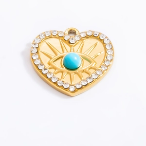 Detailed macro of a gold heart charm with a blue evil eye and sparkling rhinestones