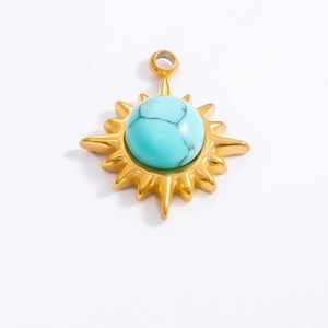 Detailed view of 18k gold sunburst pendant with turquoise inlay and radial rays