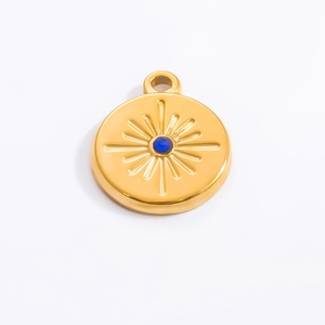 Detailed close-up of 18k gold-plated sunburst pendant with a blue center stone
