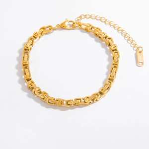 Detailed close-up of 18k gold plated stainless steel chain with lobster clasp and tag
