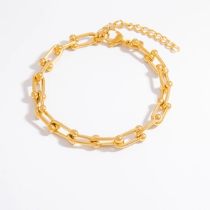 Close-up of gold U-link chain bracelet with sphere accents and adjustable lobster clasp