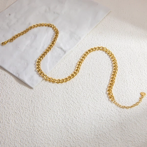 Détail d'un collier à maille gourmette en acier inoxydable plaqué or 18 carats avec cœur