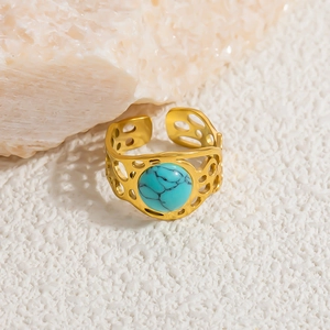 Detailed close-up of bohemian open ring with round turquoise and honeycomb metalwork