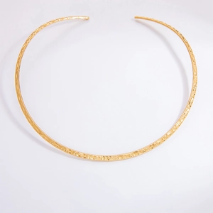 Detail of 3mm gold stainless steel choker featuring a modern hammered texture surface