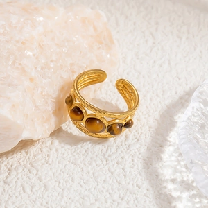 Detail of 18K gold stainless steel open ring with textured band and tiger eye stones