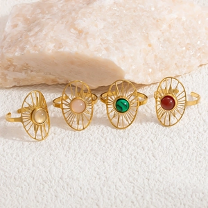 Detail of four vintage stainless steel rings featuring colorful gemstones in sunburst settings