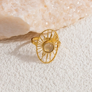 Detailed macro of gold ring with oval hollow design and moonstone on textured background