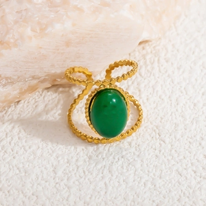 Detailed close-up of golden stainless steel ring with oval green stone and beaded edge