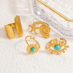 Detailed set of four 18k gold-plated rings featuring starfish, conch, and turquoise stones
