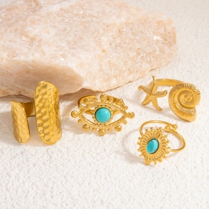 Detail of 4-piece 18k gold plated ring set with turquoise evil eye and seashell designs