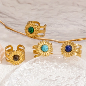 Detail of four stainless steel sunflower rings with natural stone inlays and hollow bands