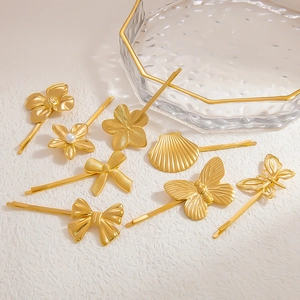 Detail view of 18K gold-plated hair clips with pearls, shells, and butterfly motifs