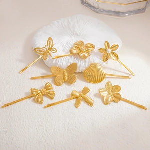 Macro detail of 18K gold stainless steel hair clips with shell and pearl floral designs