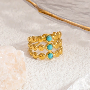 Detailed shot of gold plated three-layer stacking ring with round turquoise stones