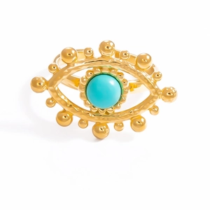 Detailed macro of golden Evil Eye ring with turquoise bead and hammered metal texture