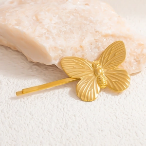 Macro view of gold-plated butterfly hair clip with detailed wing texture and metal clasp
