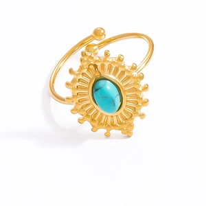 Detail of adjustable gold ring with sunburst design and oval turquoise stone inlay