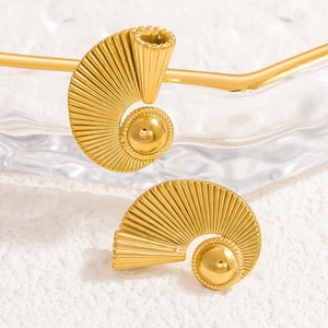 Macro detail of 18k gold wave earrings featuring radial texture and central pearl bead