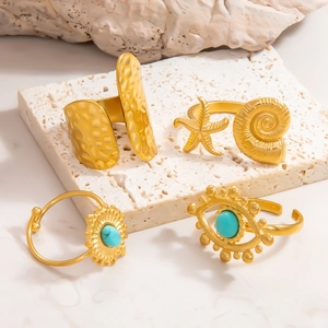 Detail of 18k gold plated stainless steel rings with starfish, conch and evil eye motifs