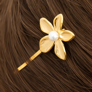 Elegant 18K gold plated flower hair clip with white pearl detail on brown hair