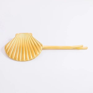 Detailed view of golden 18K gold-plated stainless steel shell hair clip with radial texture